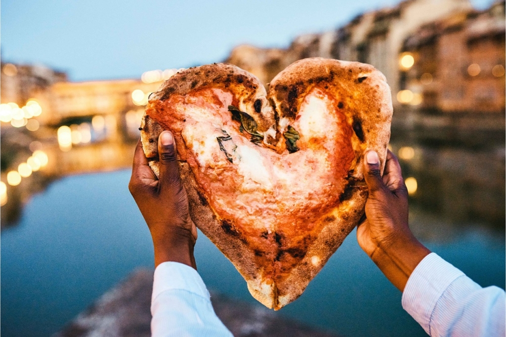 Amore per la pizza: Uomo che tiene in mano una pizza a forma di cuore