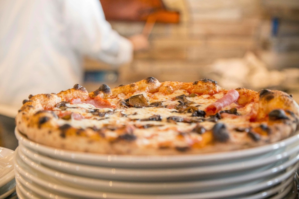 Pizza appena sfornata in una pizzeria con cornicione alto