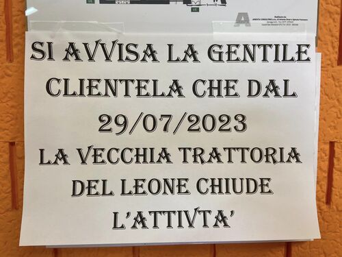 Il cartello che annuncia la chiusura dell'attività, appeso alla boiserie in legno della Vecchia Trattoria del Leone.