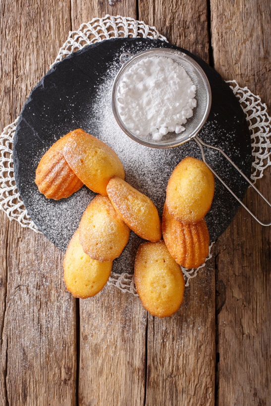 Cookies of Madeleine with sugar powder close-up on the table. 